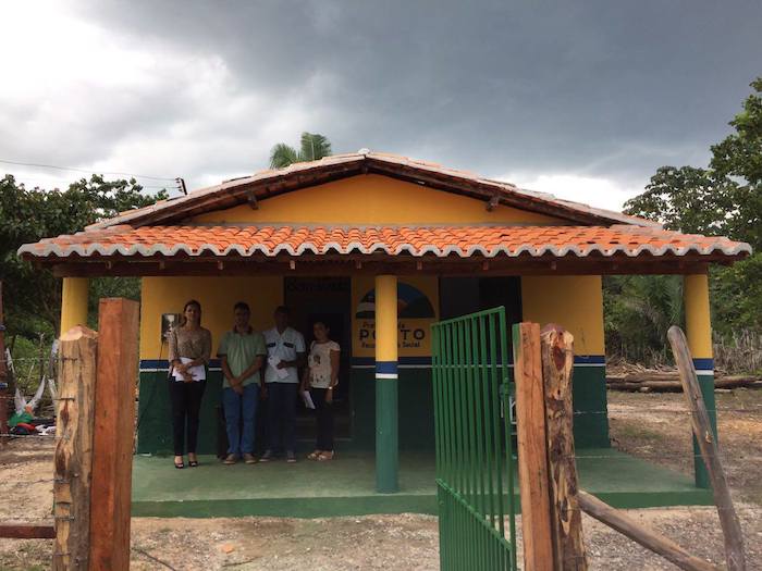 Promotora de Justiça e equipe de inspeção na frente de novo prédio de escola.