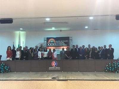 Cerca de 30 pessoas posando com um banner em que se lê