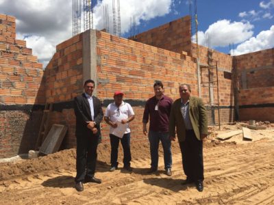Quatro pessoas posam de pé em um canteiro de obras.
