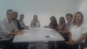 Oito pessoas reunidas em torno de uma mesa.
