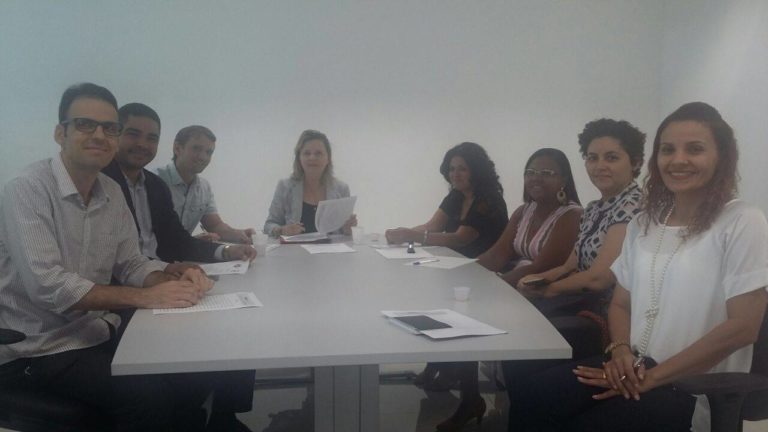 Oito pessoas reunidas em torno de uma mesa.