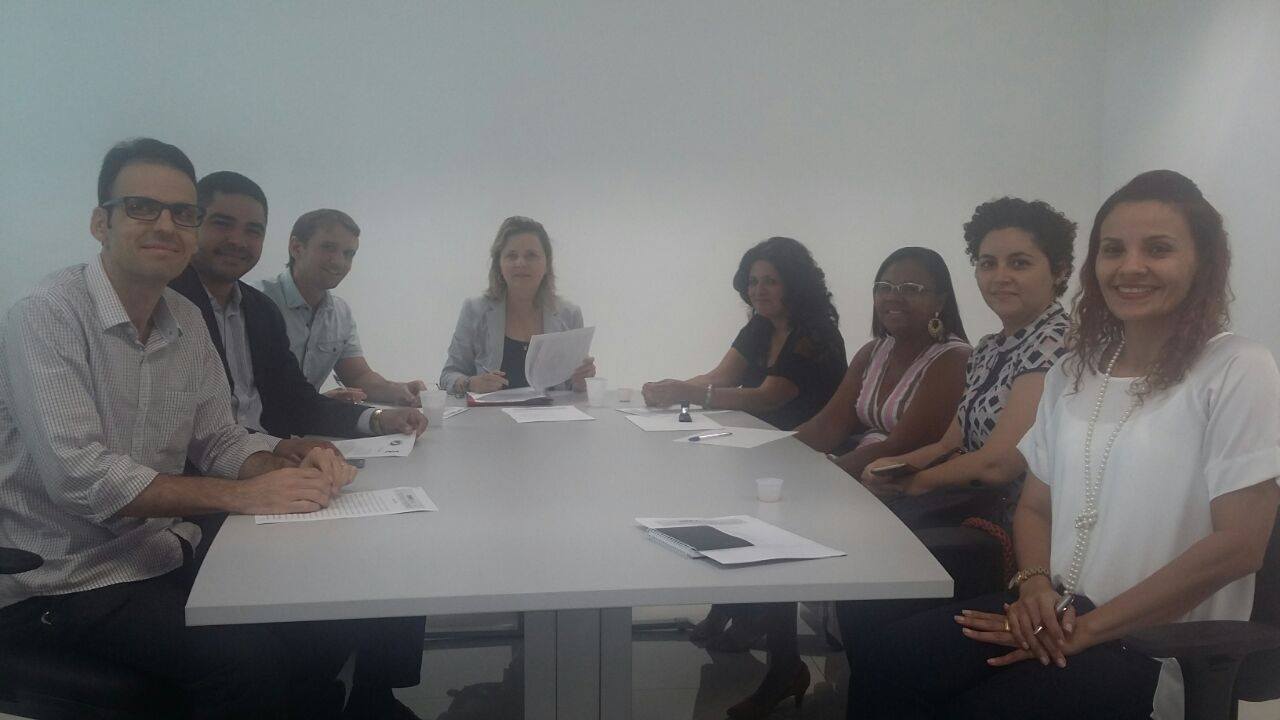 Oito pessoas reunidas em torno de uma mesa.