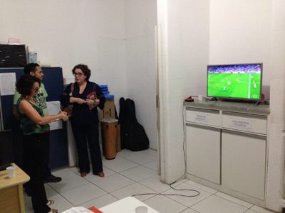 Três pessoas conversando de pé em uma sala, durante inspeção.