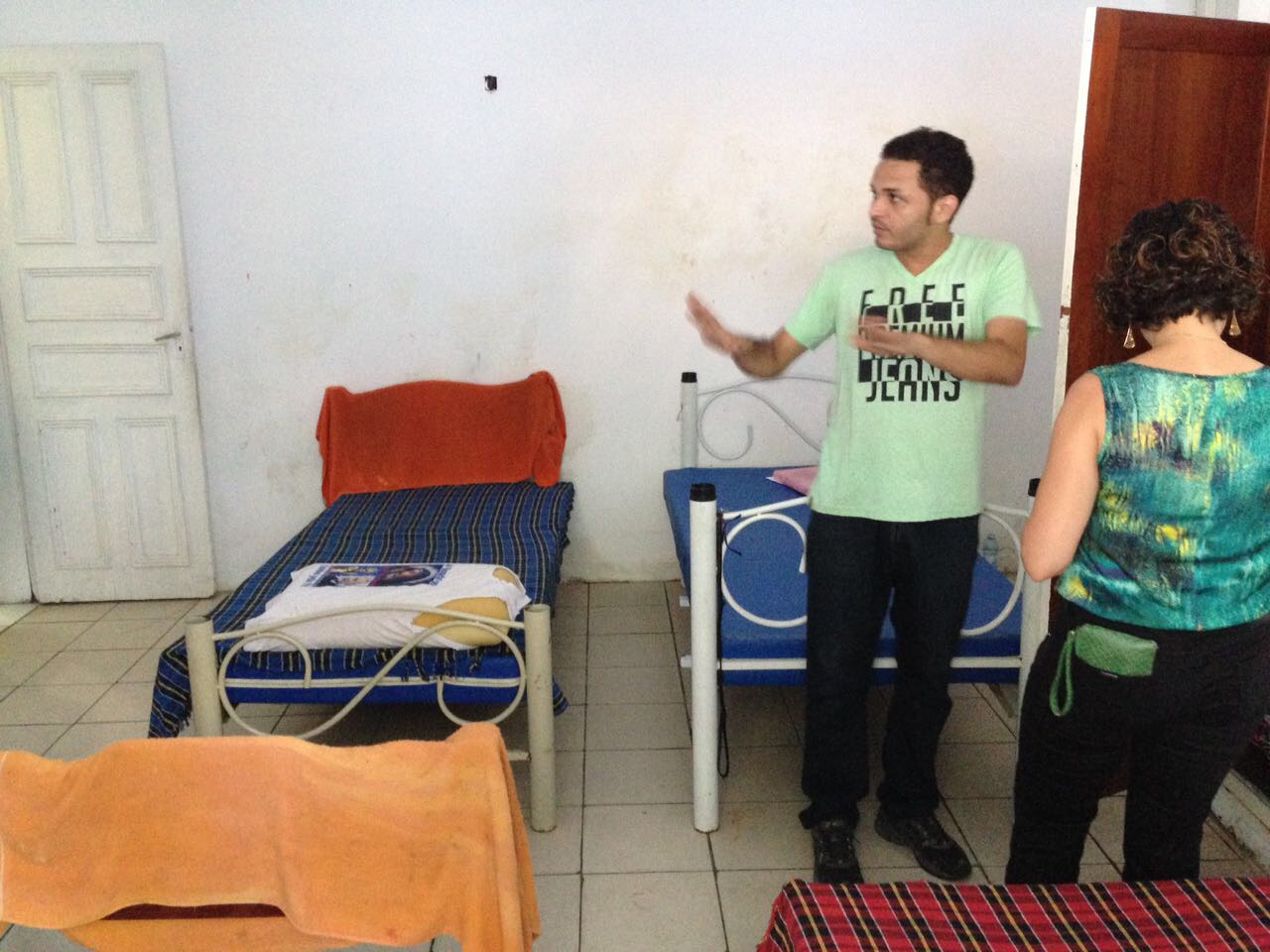 Duas pessoas examinam as estruturas de um quarto. 