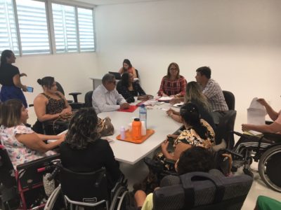 Pessoas sentadas em torno de uma mesa durante reunião