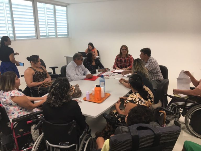 Pessoas sentadas em torno de uma mesa durante reunião