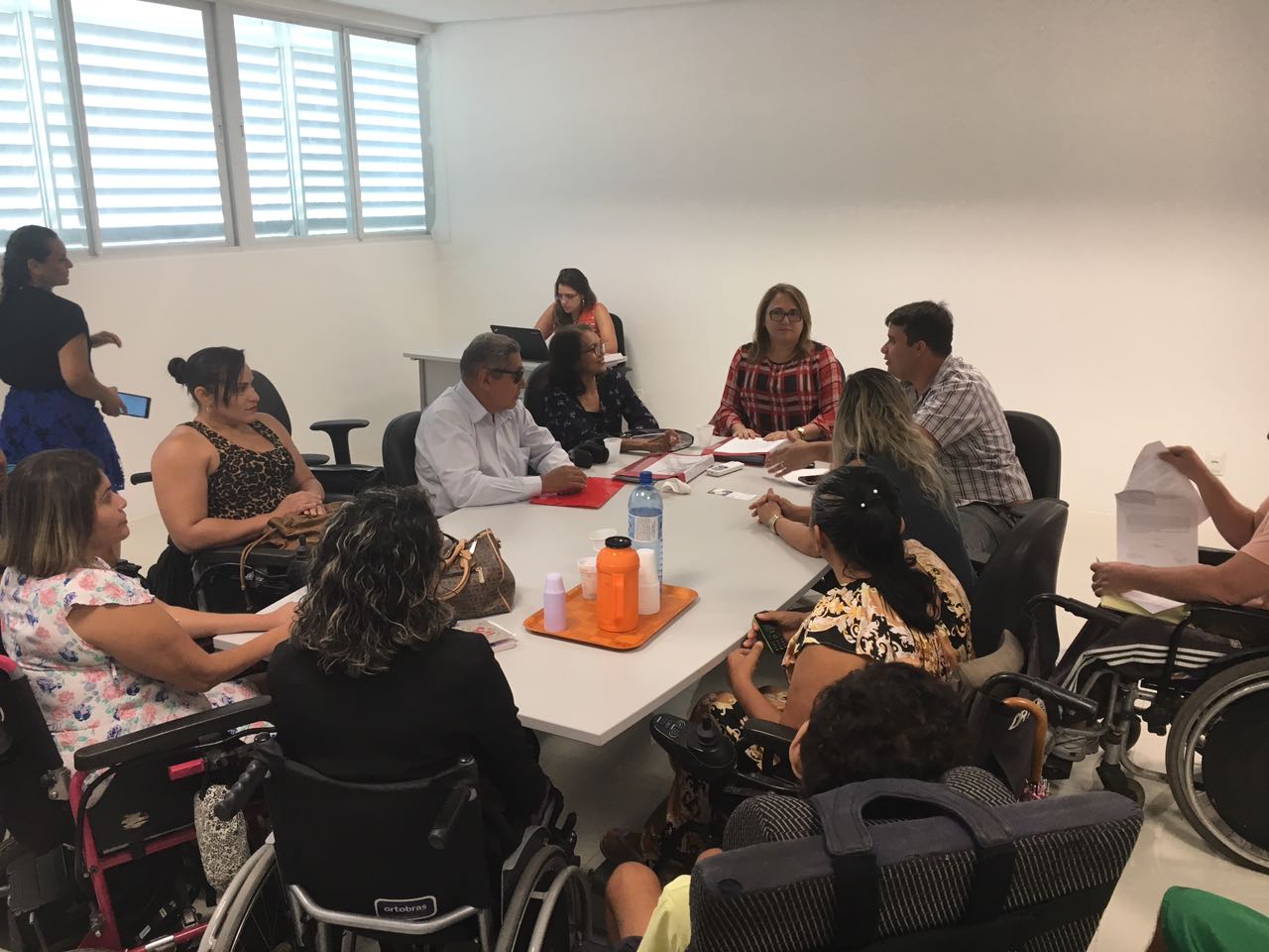 Pessoas sentadas em torno de uma mesa durante reunião 