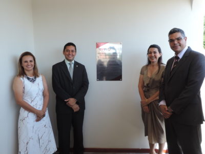 Pessoas de pé ao redor de uma placa de inauguração