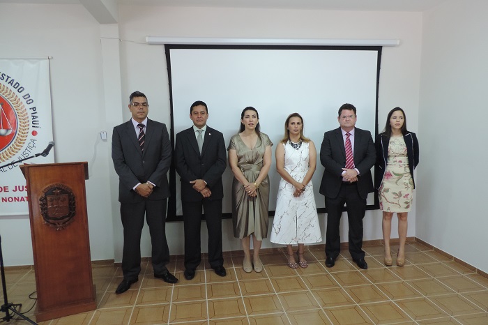 Pessoas de pé sorrindo para foto