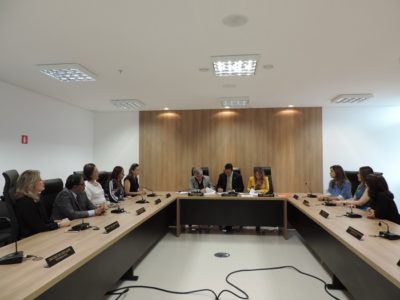 Pessoas sentadas em volta de uma mesa em formato U