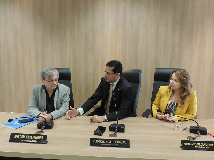 Três pessoas sentadas em torno de uma mesa 