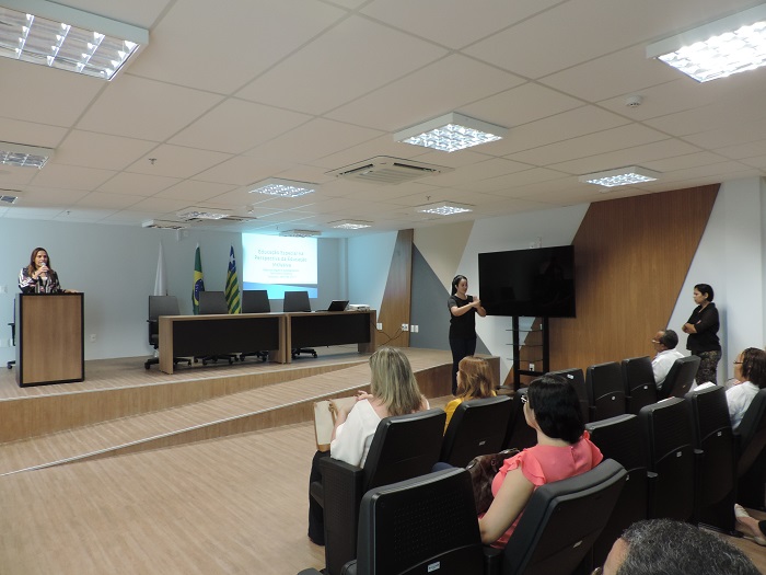 Pessoas sentadas num auditório 