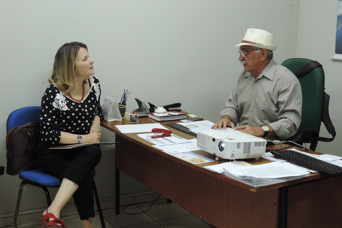 Duas pessoas sentadas conversando uma de frente para outra 