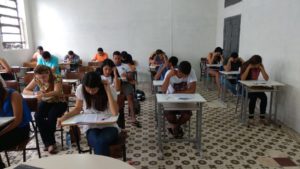 Estudantes fazendo prova em sala de aula.