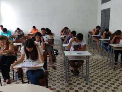 Estudantes fazendo prova em sala de aula.