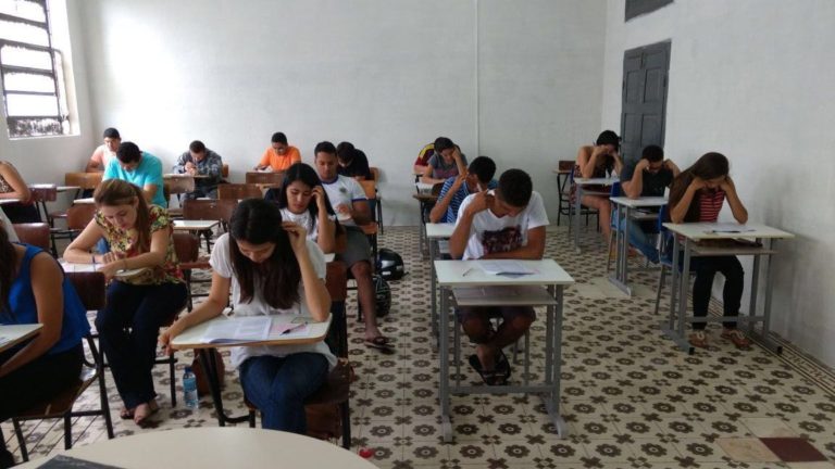 Estudantes fazendo prova em sala de aula.