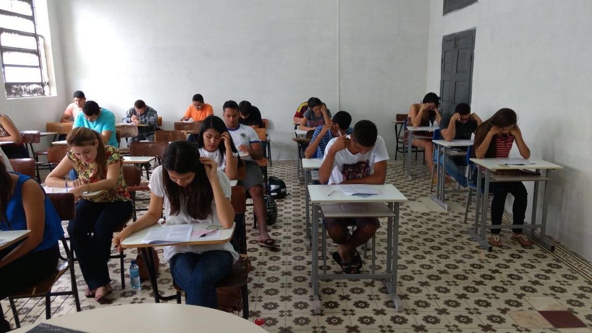 Estudantes fazendo prova em sala de aula.