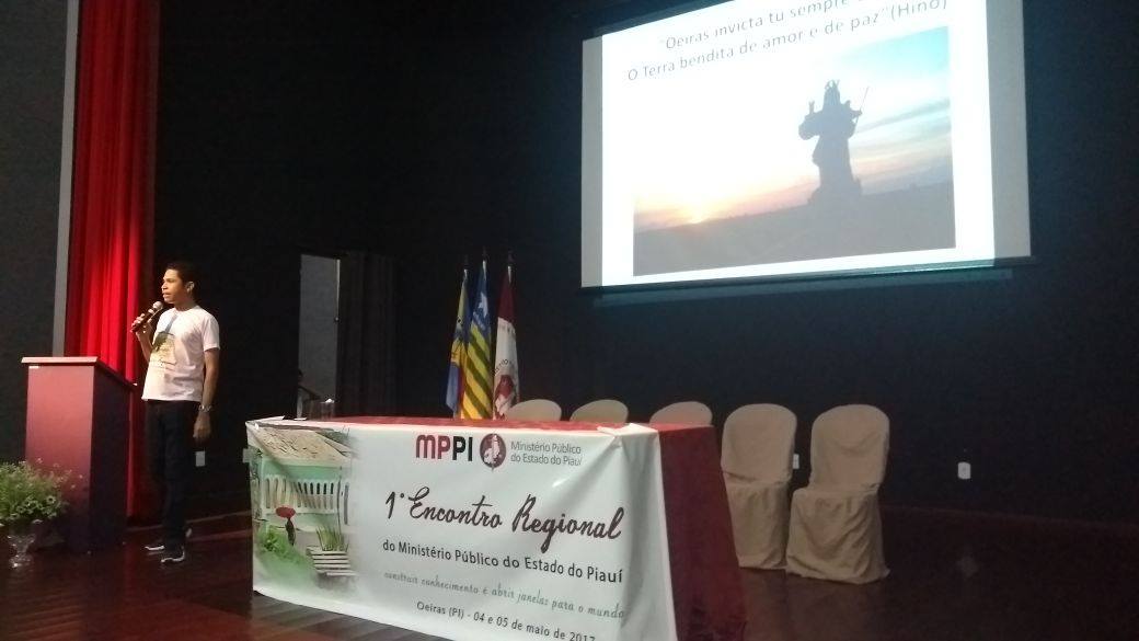 Palestrante fala ao microfone em um palco.