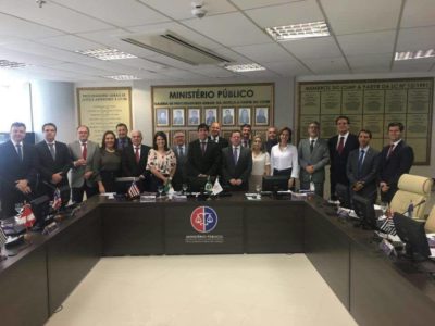 Cerca de 20 pessoas estão de pé, sorrindo, em uma sala do Ministério Público do Maranhão.
