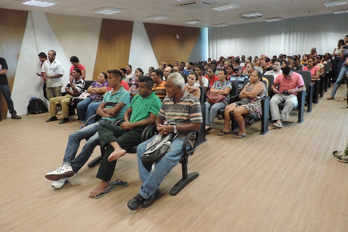 Pessoas sentadas em auditório acompanhando audiência