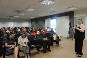 Pessoas sentadas, um mulher de pé