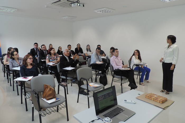 Pessoas sentadas assistindo aula 