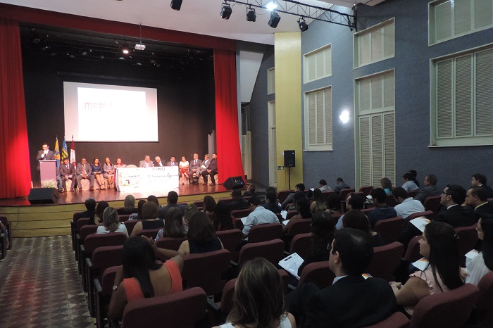 Auditório com pessoas sentadas 