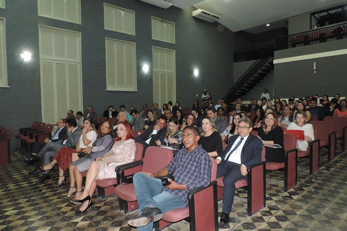 Pessoas sentadas num auditório 
