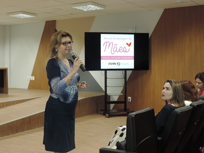 Mulher de pé com microfone na mão 