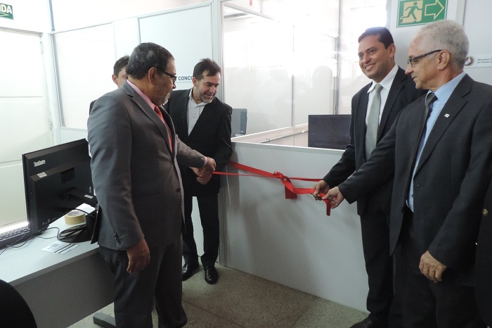 Homens segurando fita inaugurativa