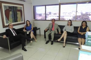 Cincos pessoas sentadas sorrindo para fotografia