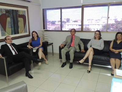 Cincos pessoas sentadas sorrindo para fotografia