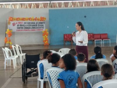 Mulher de pé falando para crianças