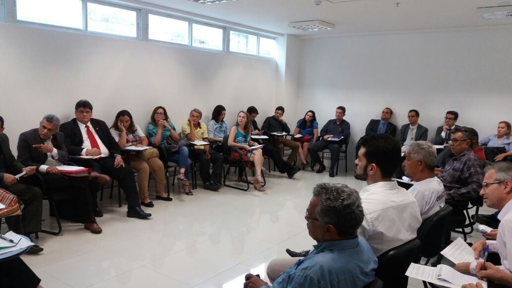 Pessoas reunidas em sala de aula, com as carteiras em círculo.