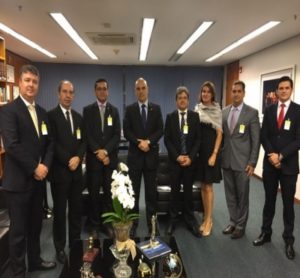 Homens de terno posam de pé durante reunião.