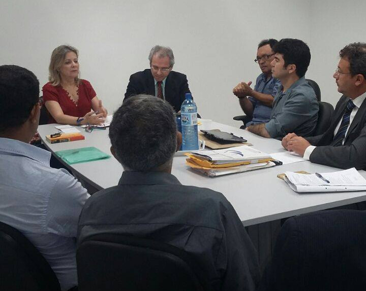 Audiência. Pessoas reunidas em torno de uma mesa.