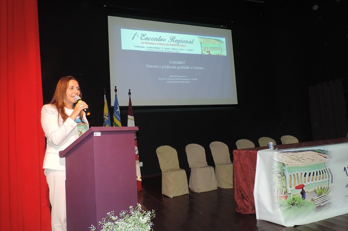 Procuradora de Justiça Raquel Normando falando junto a uma tribuna.