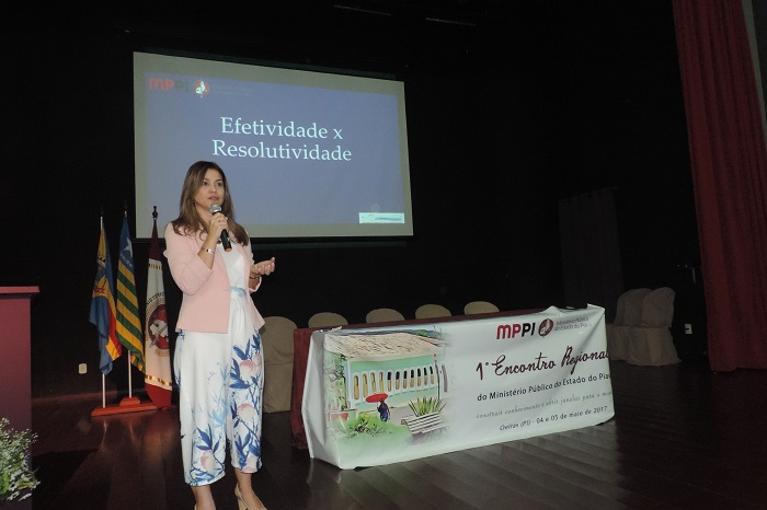 Palestrante fala o microfone em um palco.