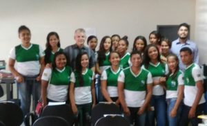 Promotor de Justiça rodeadopor estudantes em uma sala.