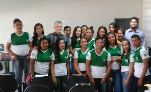 Promotor de Justiça rodeadopor estudantes em uma sala.