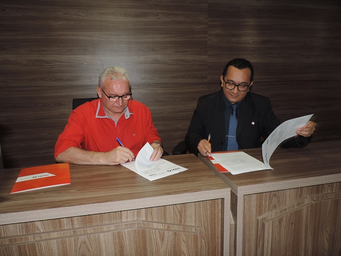 Homens sentados assinando documento