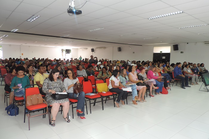 Pessoas sentadas em auditório assistindo palestra 