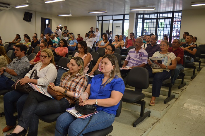 Pessoas sentadas num platéia assistindo palestra 