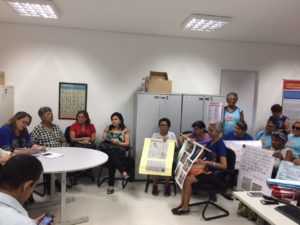 Sala lotada de pessoas, com cartazes de protesto.