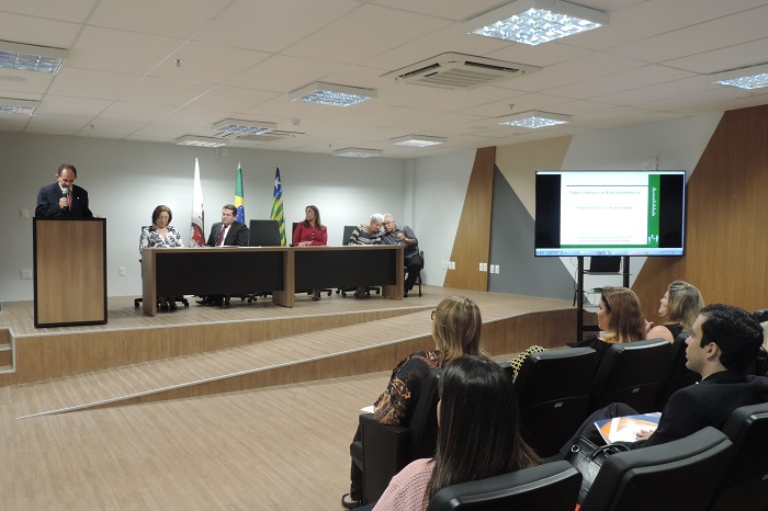 Procurador-Geral de Justiça fala ao microfone, de pé, diante de uma tribuna.