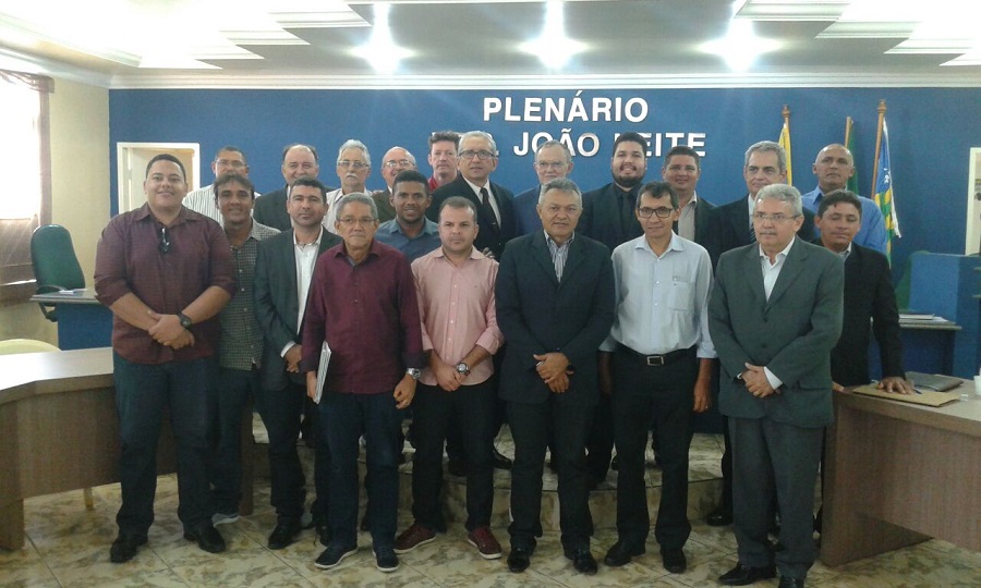 Vários homens de pé, posando em um plenário.