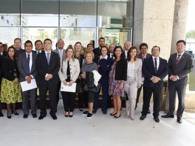 Pessoas posando de pé, com roupas formais