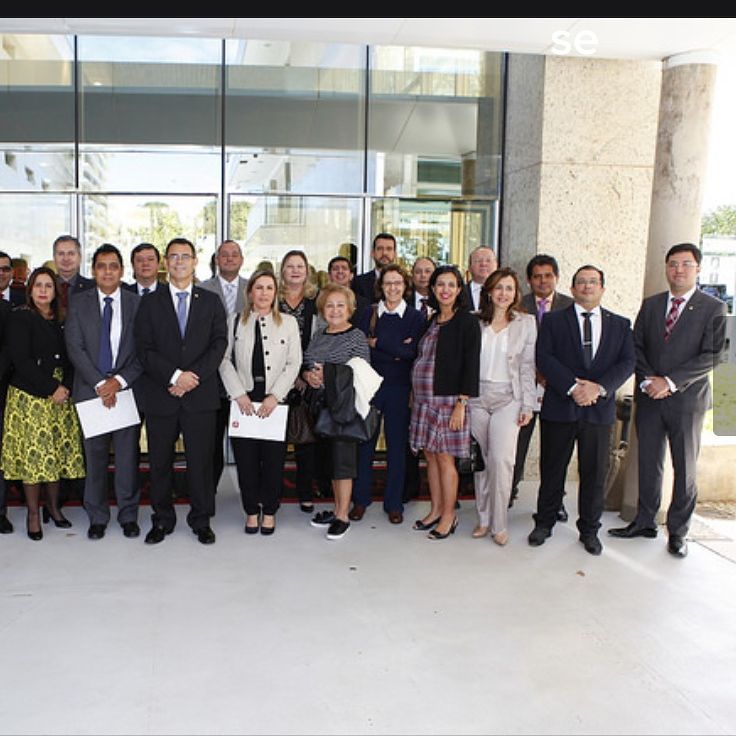 Pessoas posando de pé, com roupas formais