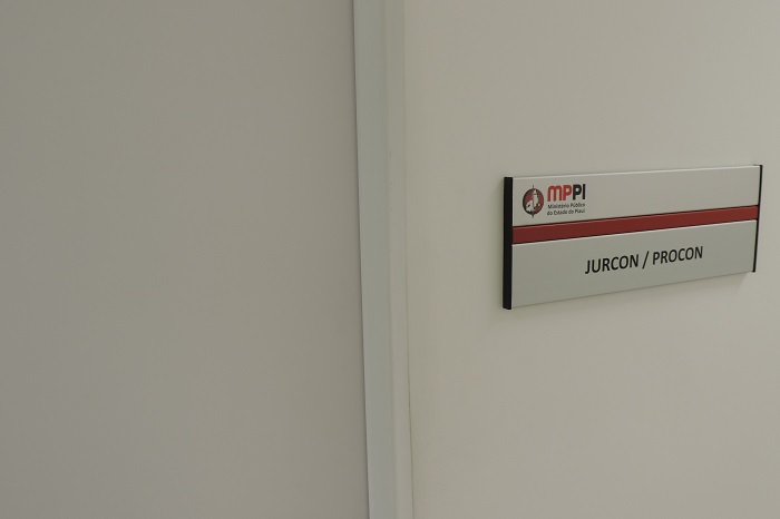 Porta de sala, ao lado da qual há uma placa onde se lê 