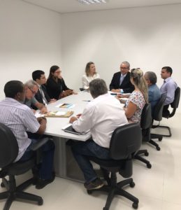 Pessoas sentadas em torno de uma mesa durante reunião